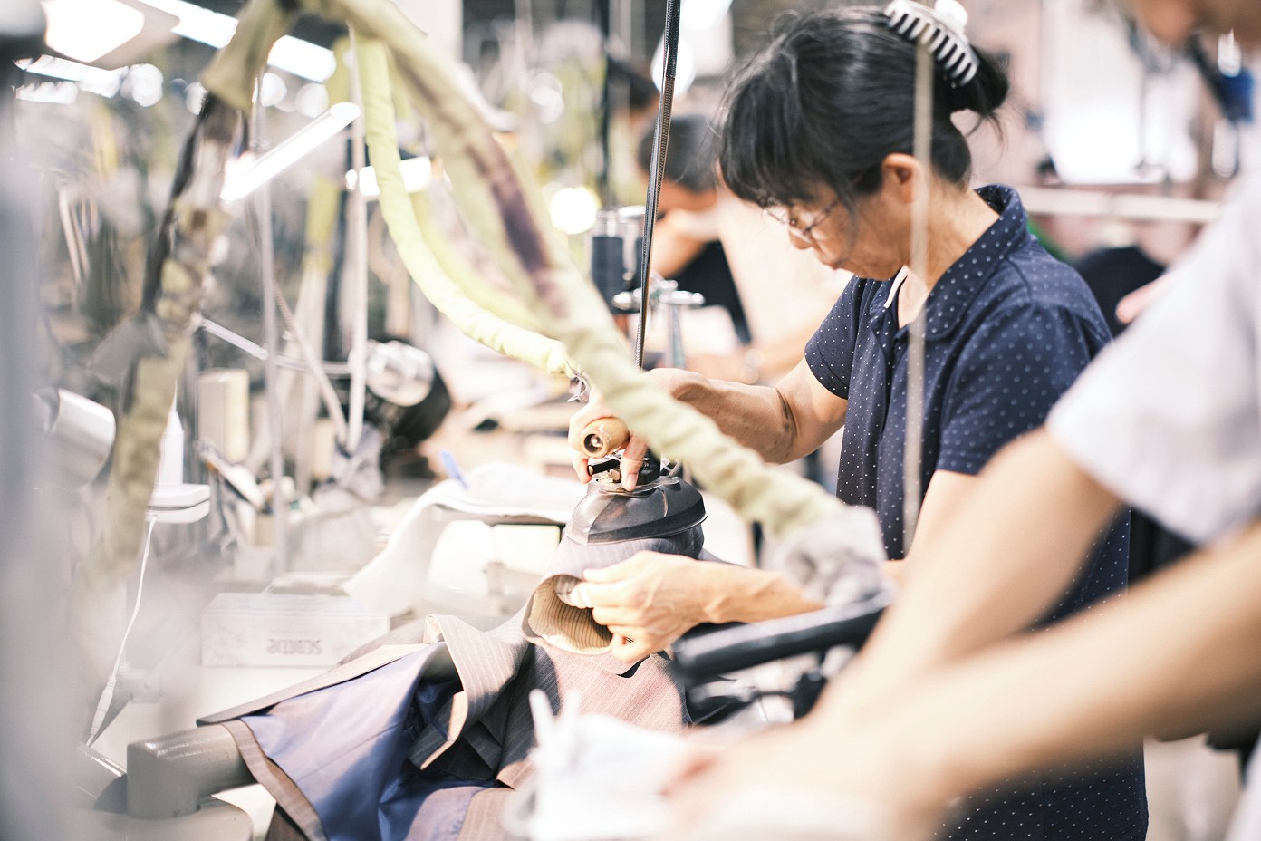 ミシンが並ぶラインで縫製を進める職人たち